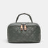 A dark gray quilted cosmetic bag with a top handle, featuring two rose gold zipper pulls with crystal accents, set against a light gray background.
