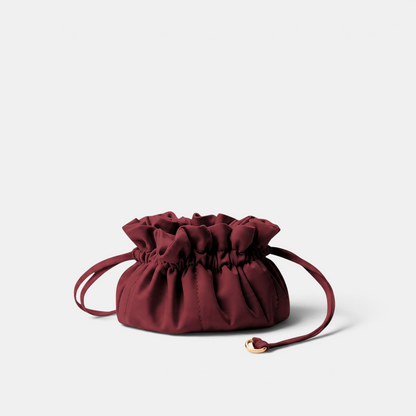 Shop Rescue Spa Lotus Petit jewelry pouch in deep burgundy neoprene with a drawstring closure and gold hardware.
