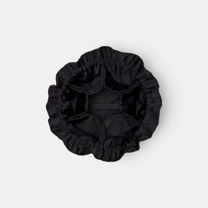 Shop Rescue Spa Naghedi Lotus Petit black neoprene jewelry pouch with drawstring closure and interior pockets