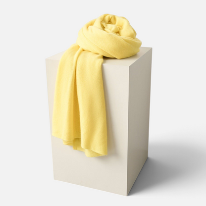 Shop Rescue Spa yellow cashmere travel wrap draped over a minimalist display pedestal