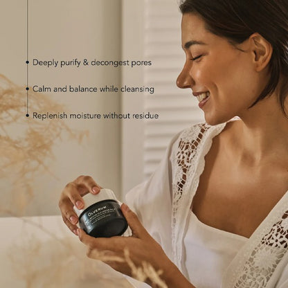 Woman holding a jar of Olverum Alpine Cleansing Balm with text about its benefits on a neutral background