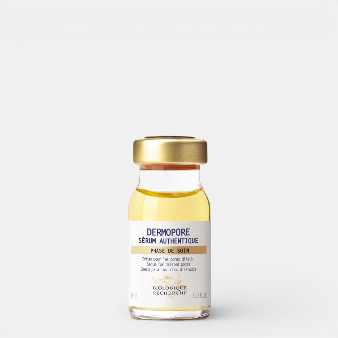 Small 0.3 fl.oz glass bottle of Biologique Recherche Serum Dermopore with a gold cap and white label featuring blue text, shown upright on a white background. A targeted serum formulated to minimize enlarged pores, control oil, and smooth uneven skin texture