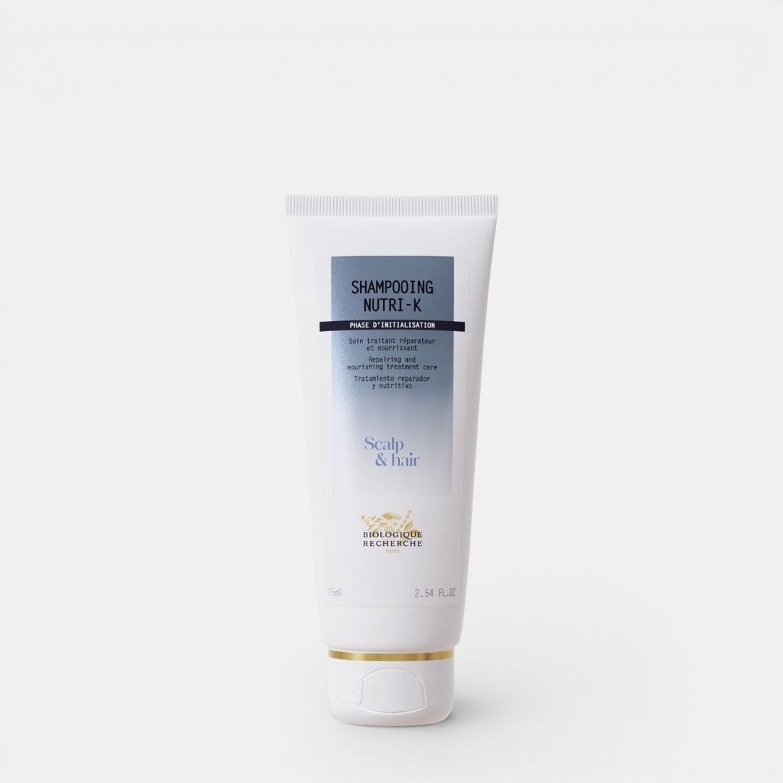 Biologique Recherche Shampooing Nutri-K in a white, squeezable tube with blue lettering and the Biologique Recherche logo, displayed on a clean white background. A nourishing shampoo designed to repair and hydrate dry, damaged hair. Size 2.54
