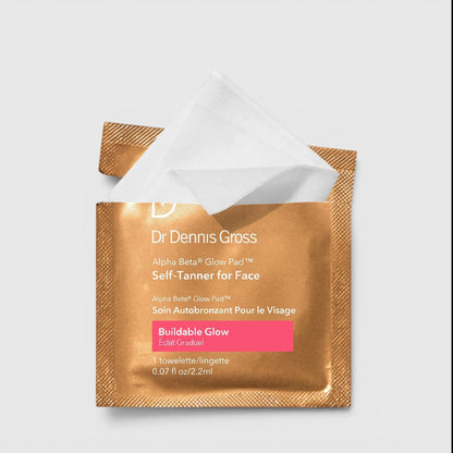 Shop Rescue Spa Dr. Dennis Gross Alpha Beta Glow Pad single-use facial self-tanning towelette in gold foil packaging.
