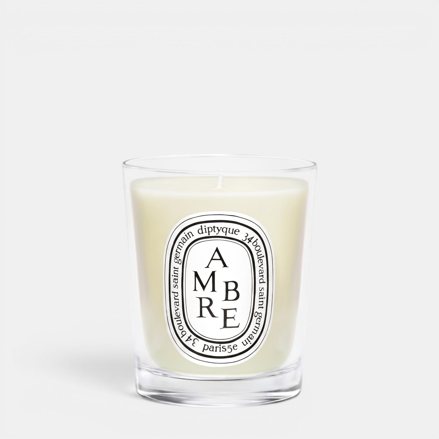 Shop Rescue Spa Ambre scented candle in a clear glass jar with a signature oval white label and woody fragrance.