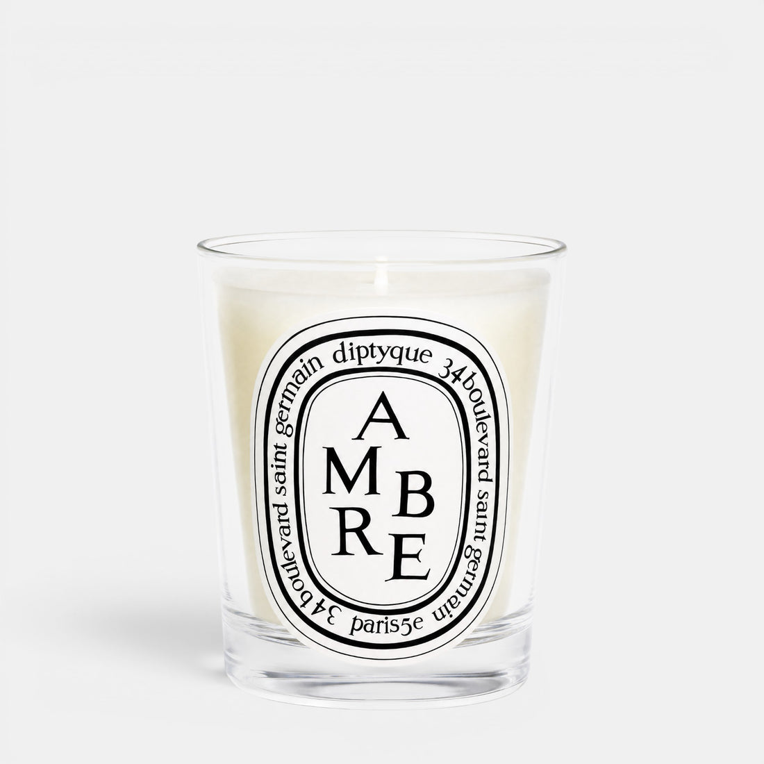 Shop Rescue Spa Ambre woody scented candle in a clear glass jar with a signature oval label
