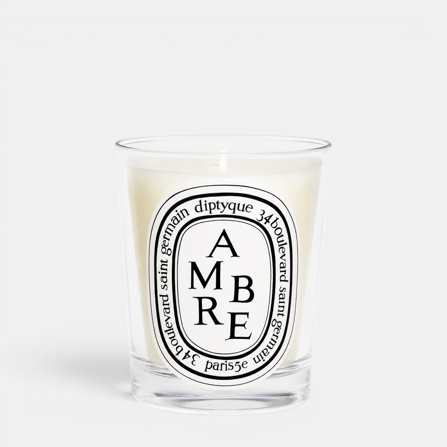 Shop Rescue Spa Ambre woody scented candle in a clear glass jar with a signature oval label
