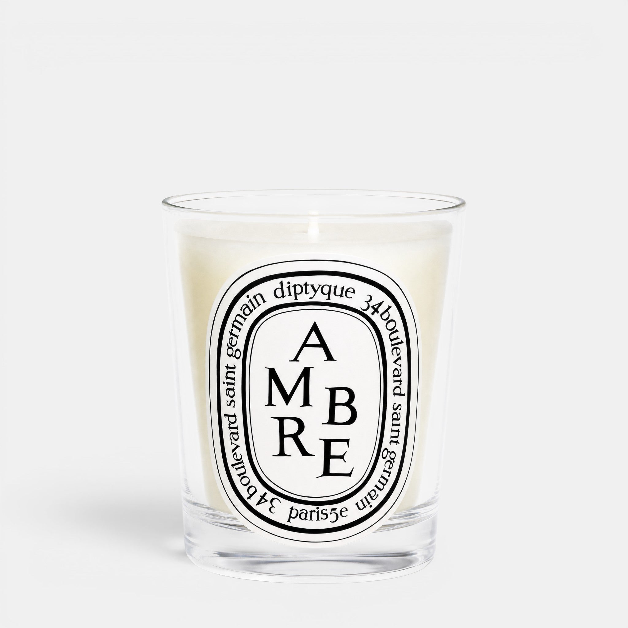 Shop Rescue Spa Ambre woody scented candle in a clear glass jar with a signature oval label