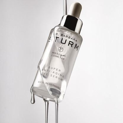 Shop Rescue Spa Dr. Barbara Sturm Super Anti-Aging Eye Serum bottle with clear liquid dripping from the dropper
