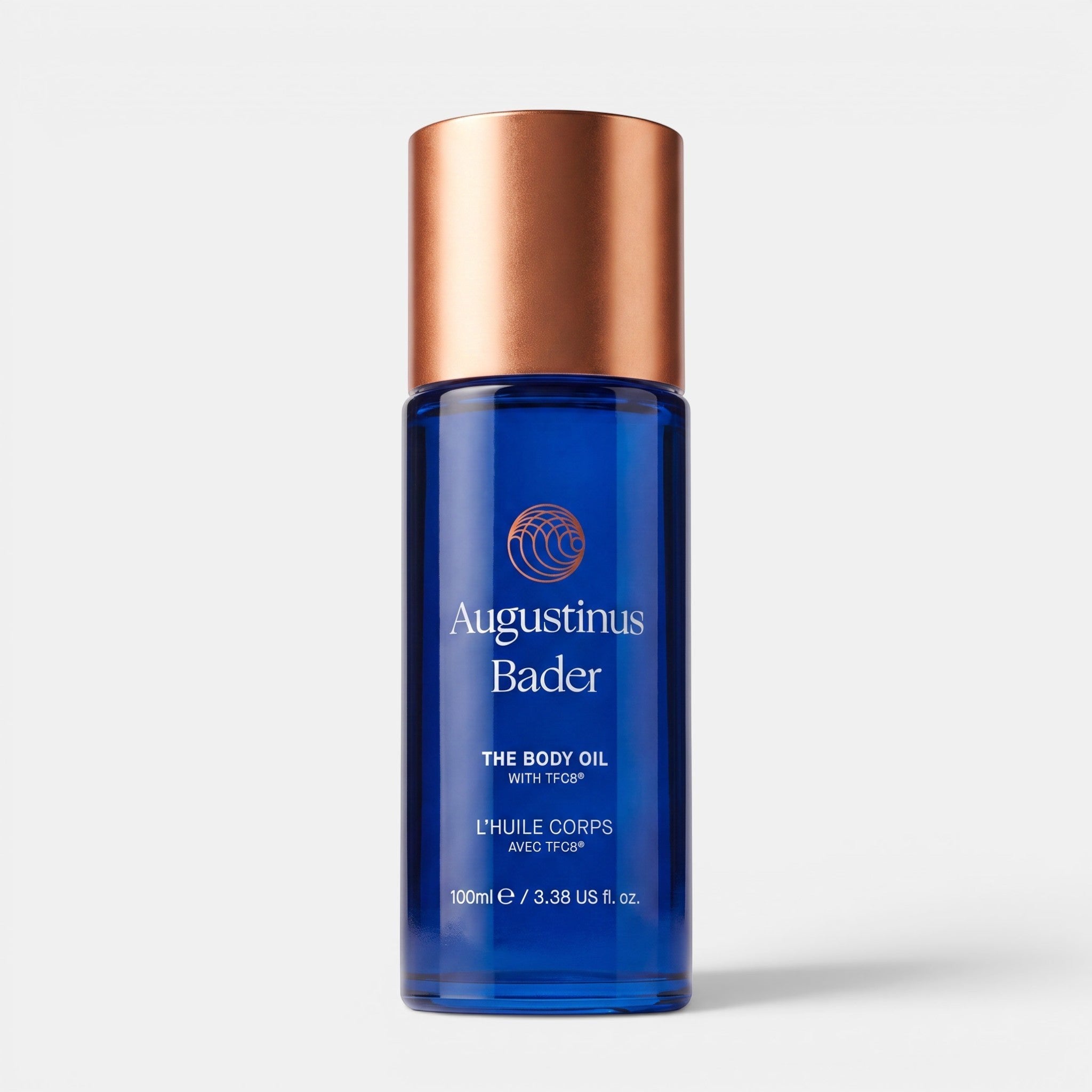 Shop Rescue Spa Augustinus Bader The Body Oil in a blue glass bottle with a metallic copper cap, 100 mL size.