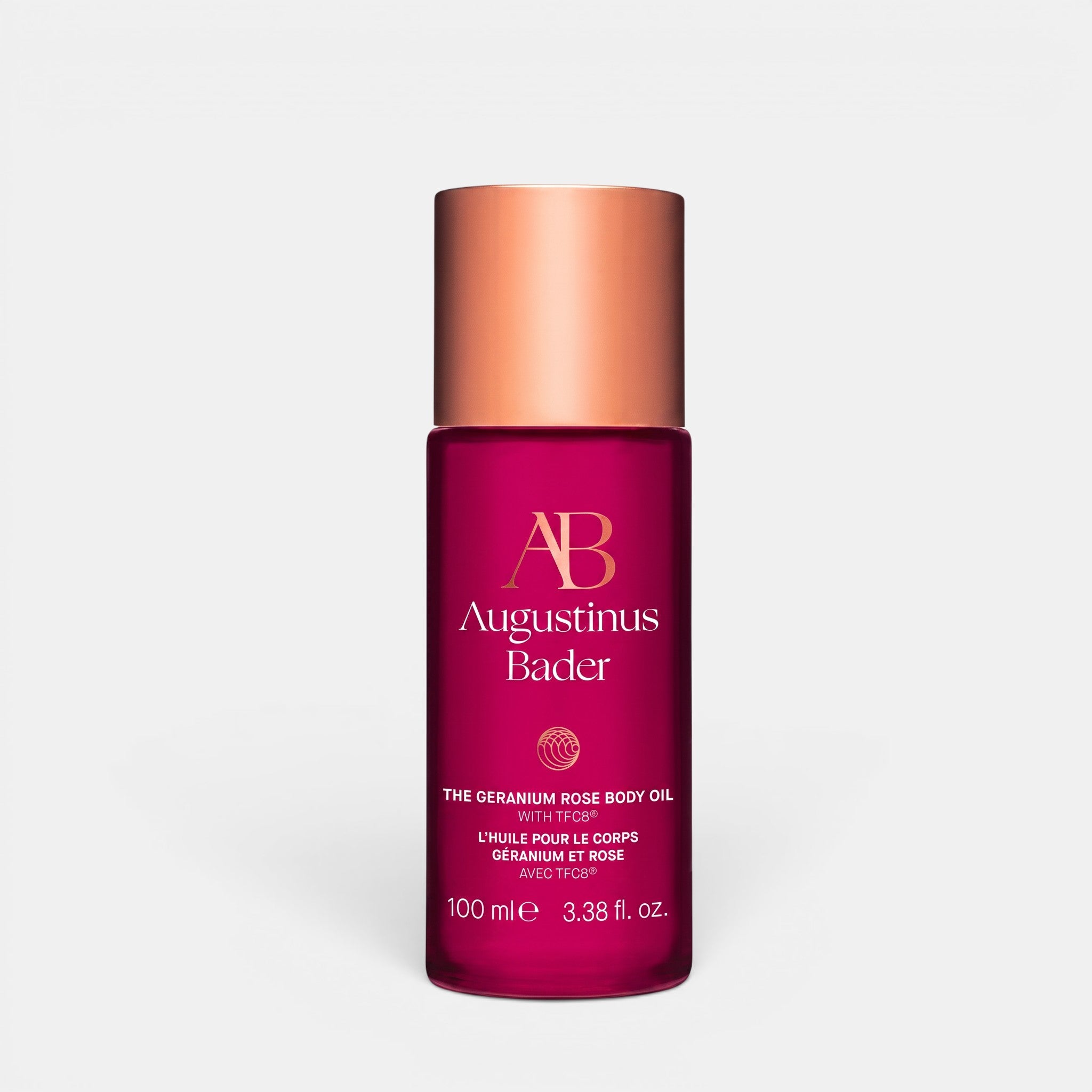 Shop Rescue Spa Augustinus Bader The Geranium Rose Body Oil in a deep pink 100ml bottle with a metallic copper cap.