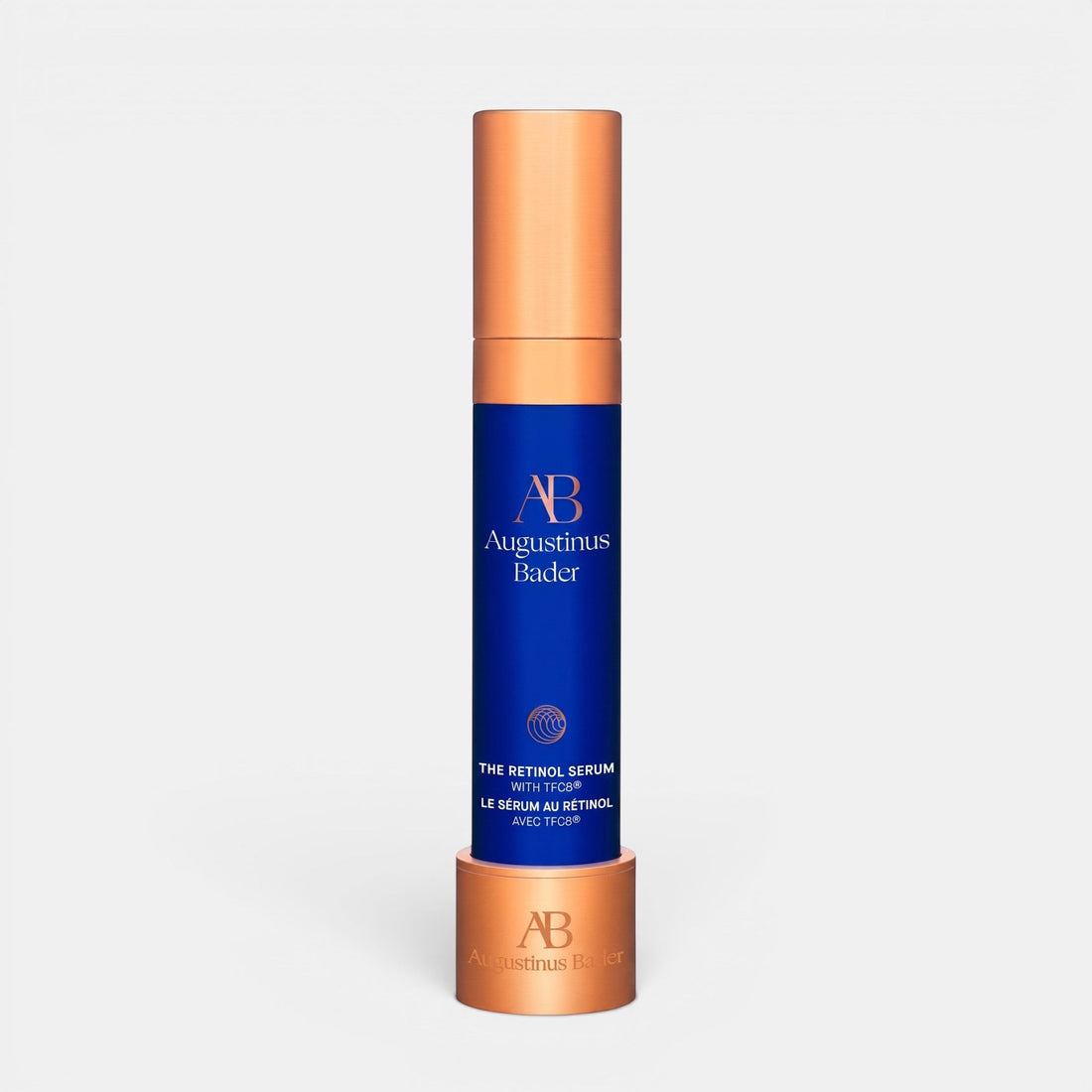 Shop Rescue Spa Augustinus Bader The Retinol Serum in a blue and copper bottle with a matching display stand.