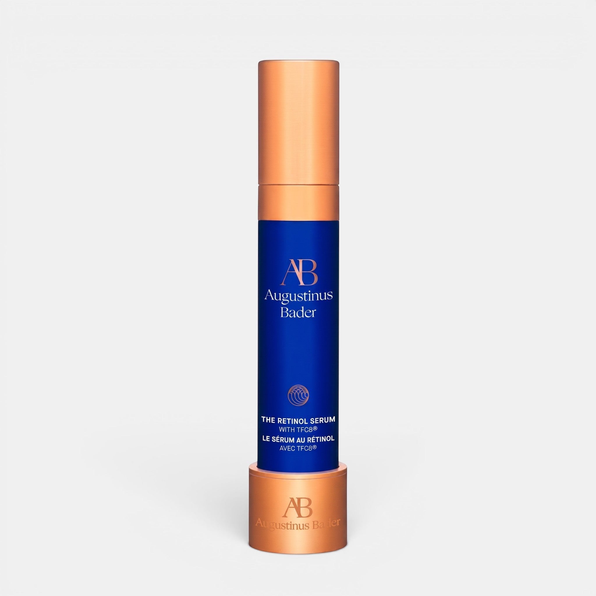 Shop Rescue Spa Augustinus Bader The Retinol Serum in a blue and copper bottle with a matching display stand.