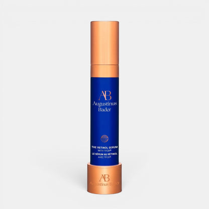 Shop Rescue Spa Augustinus Bader The Retinol Serum in a blue and copper bottle with a matching display stand.