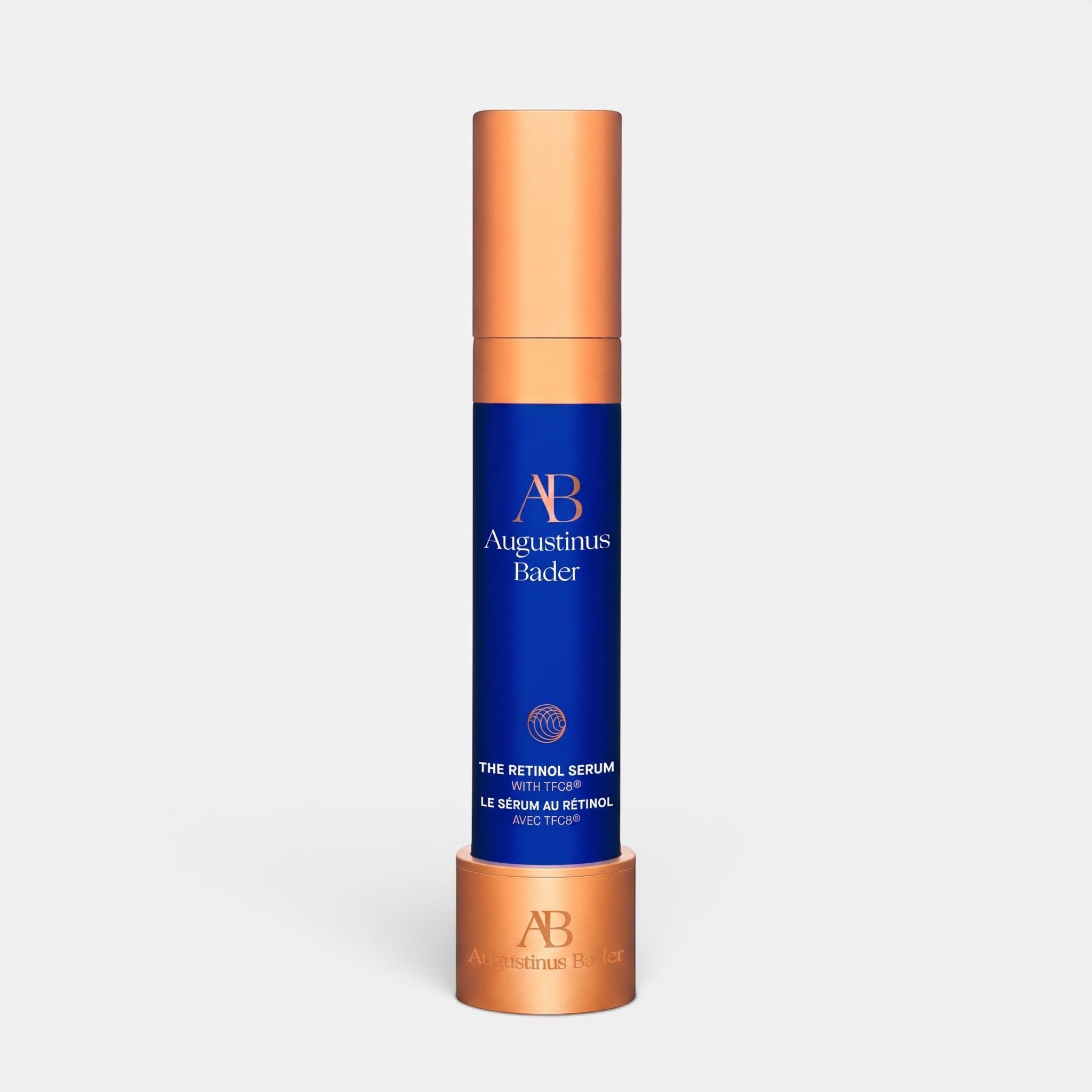Shop Rescue Spa Augustinus Bader The Retinol Serum in a blue bottle with a metallic copper cap and matching stand.