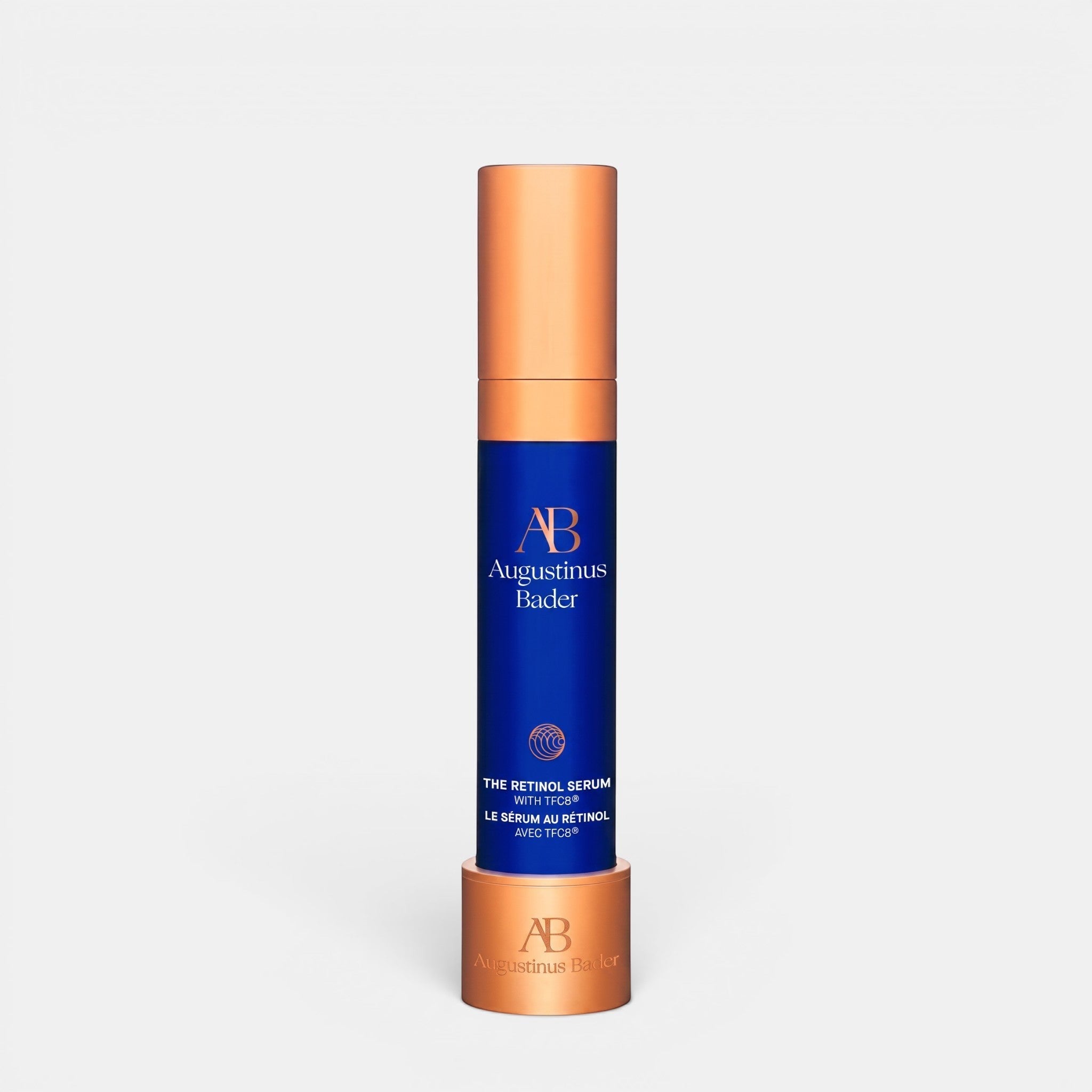 Shop Rescue Spa Augustinus Bader The Retinol Serum in a blue bottle with a metallic copper cap and base stand