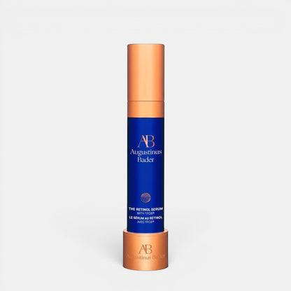 Shop Rescue Spa Augustinus Bader The Retinol Serum in a blue bottle with a metallic copper cap and base stand