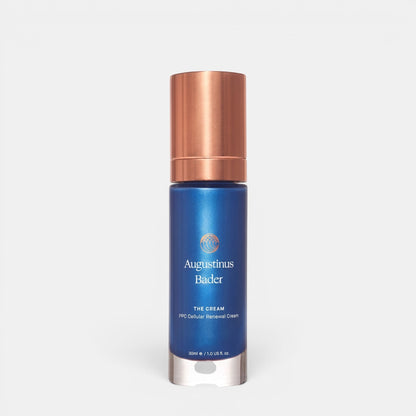 Shop Rescue Spa Augustinus Bader The Cream in a blue bottle with a metallic copper cap for skin rejuvenation.