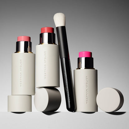 Shop Rescue Spa Baby Blender Brush with soft nylon bristles next to Westman Atelier cream blush sticks