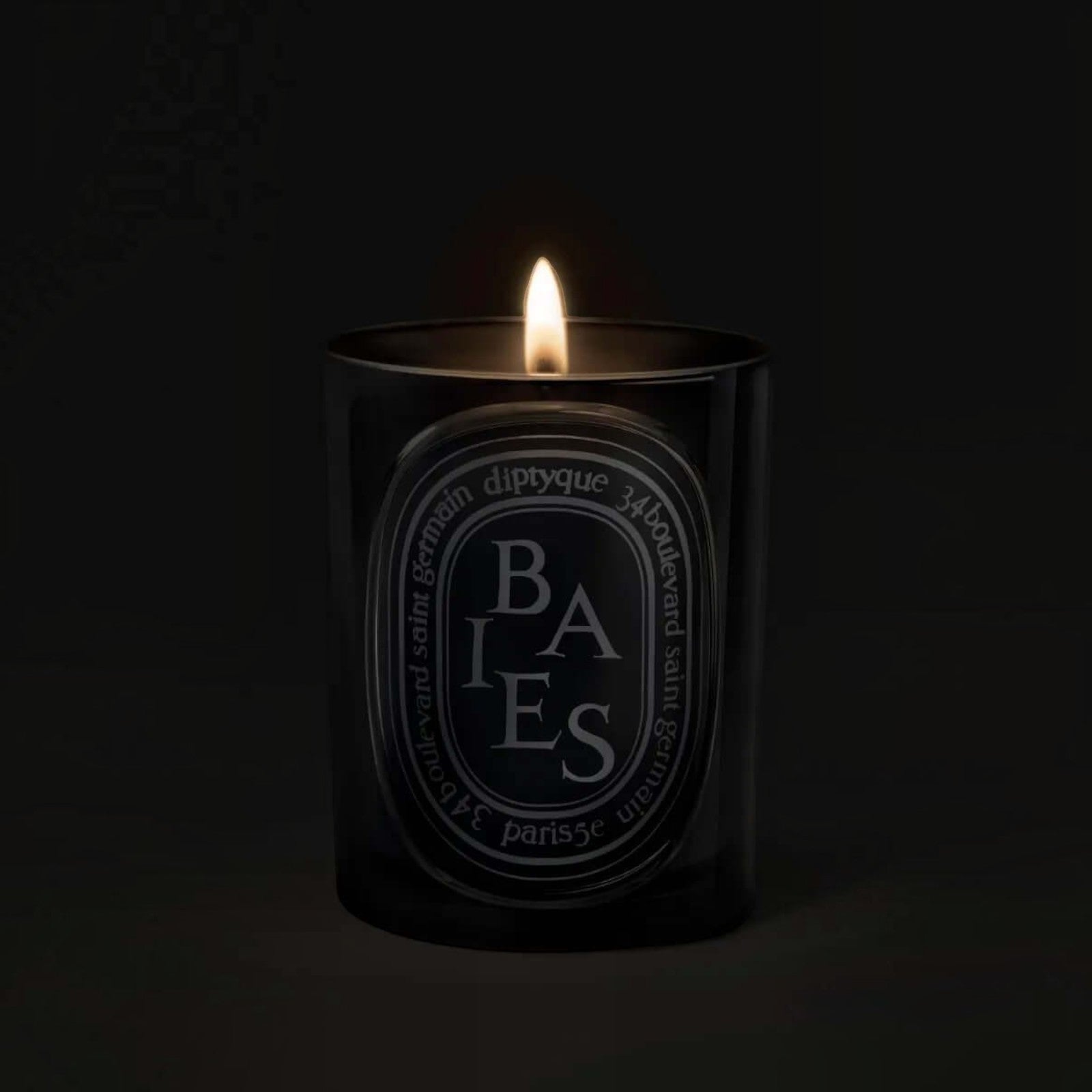 Shop Rescue Spa Baies scented candle in a black glass vessel with a glowing flame against a dark background