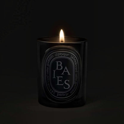 Shop Rescue Spa Baies scented candle in a black glass vessel with a glowing flame against a dark background