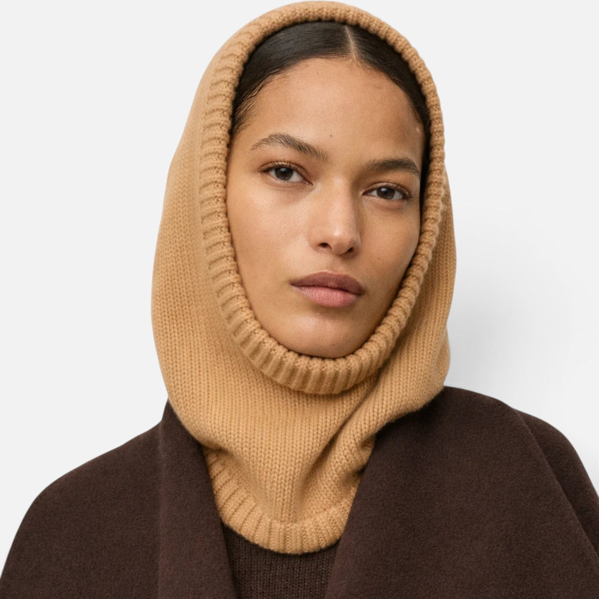 Model wearing a Shop Rescue Spa chunky knit beige cashmere balaclava with a ribbed edge over a dark brown coat.