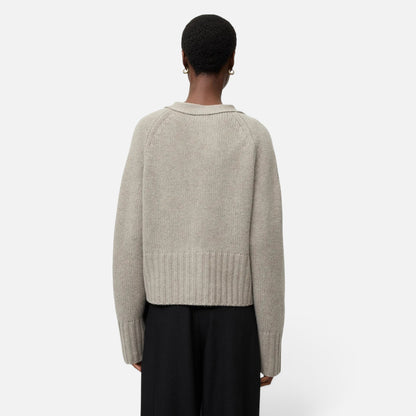 Back view of a model wearing a Shop Rescue Spa chunky knit beige cashmere cardigan with a relaxed fit