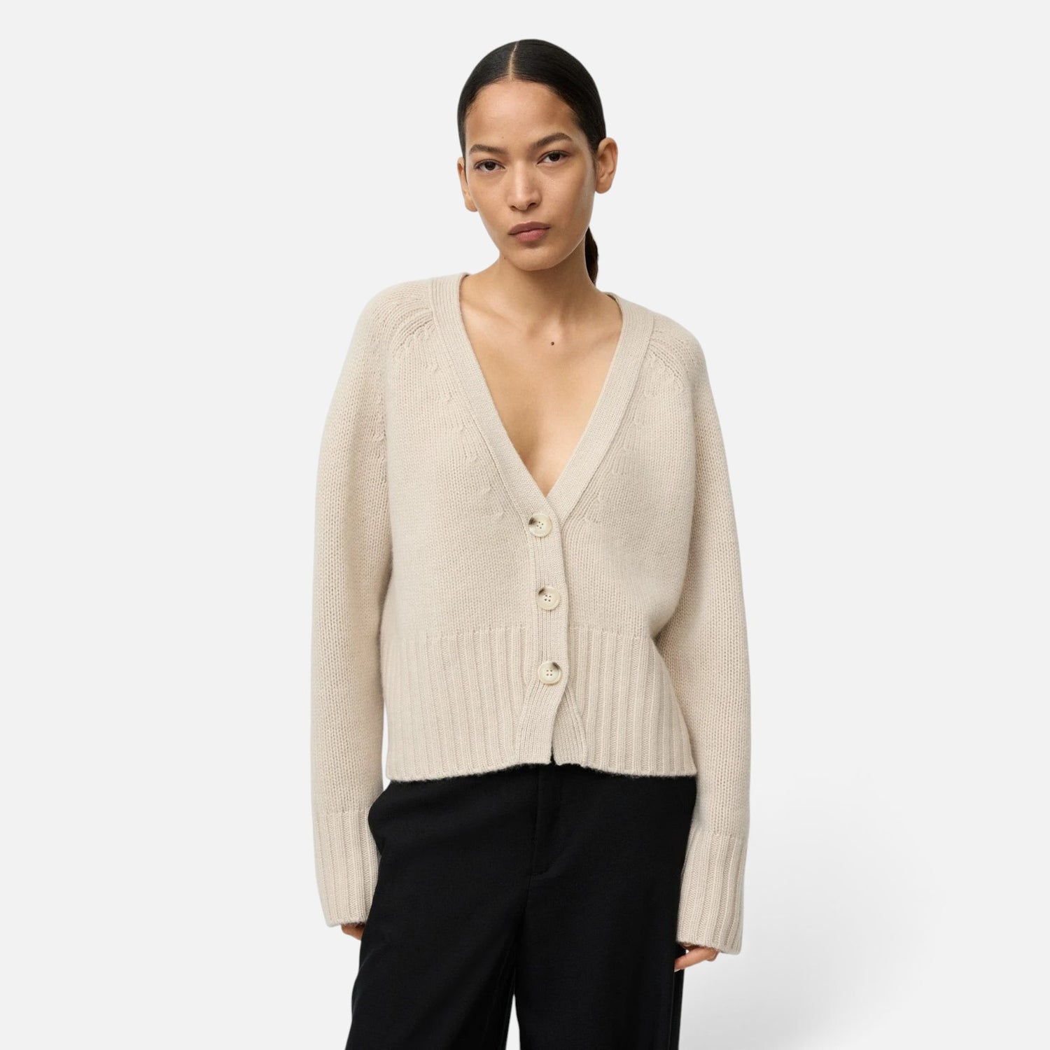 Shop Rescue Spa beige chunky knit cashmere V-neck cardigan with button front worn by a model