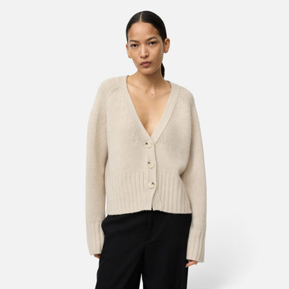 Shop Rescue Spa beige chunky knit cashmere V-neck cardigan with button front worn by a model