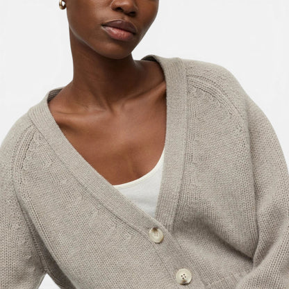 Shop Rescue Spa chunky beige cashmere V-neck cardigan with button-front closure worn by a model