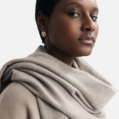 Shop Rescue Spa unisex fine knit beige cashmere scarf worn by a model with gold hoop earrings