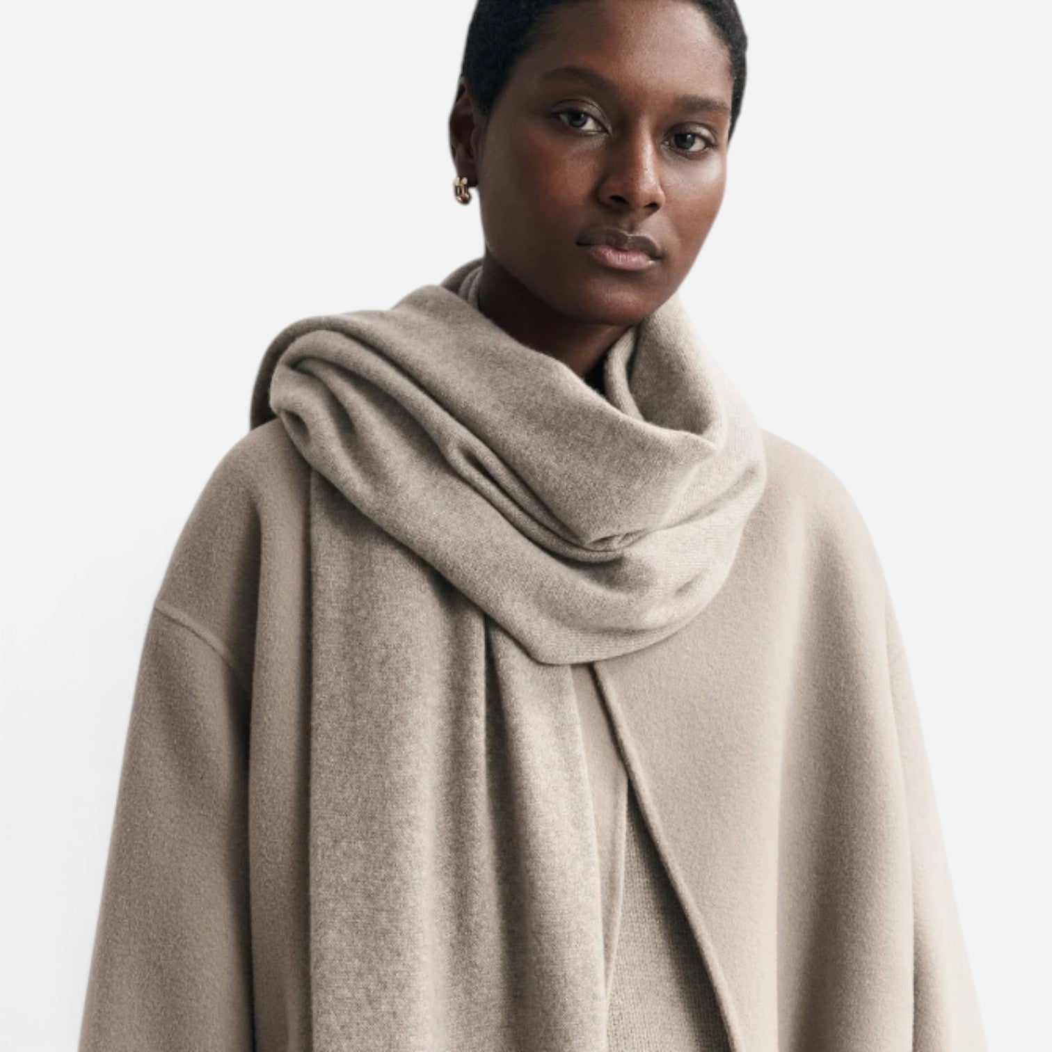 Shop Rescue Spa unisex fine knit beige cashmere scarf worn by a model in a matching coat