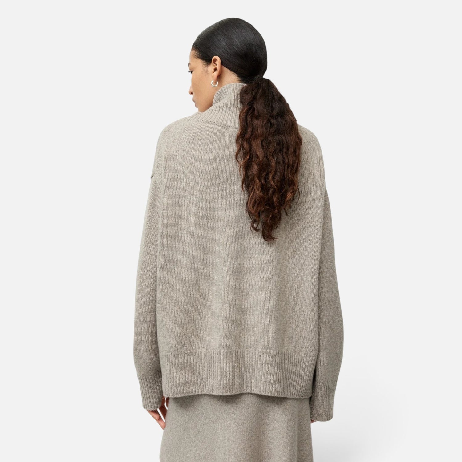Shop Rescue Spa oversized beige cashmere turtleneck sweater in a chunky knit, back view on a model.