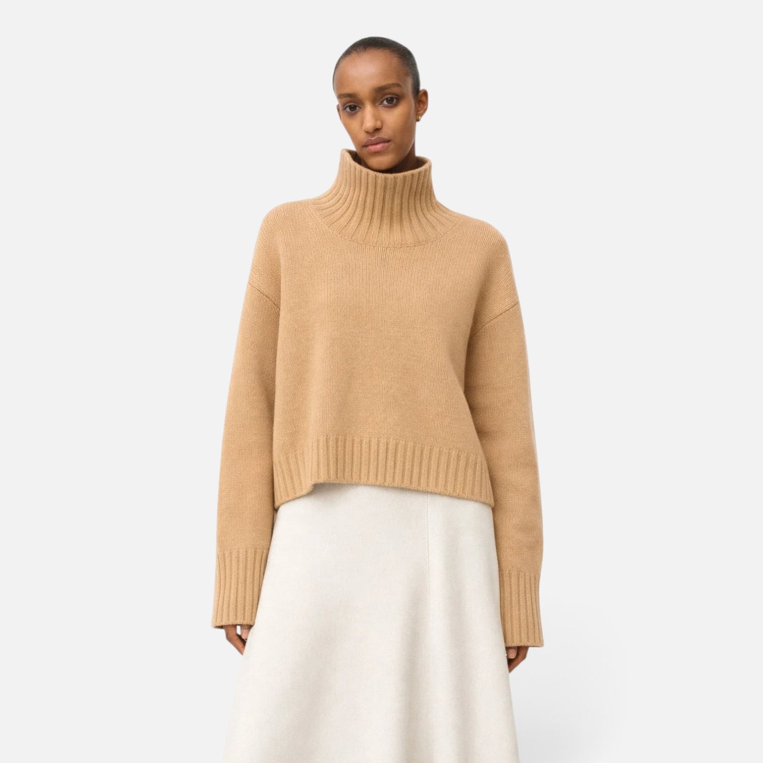 Shop Rescue Spa Girlfriend turtleneck sweater in beige chunky cashmere with sleeve slits worn by a model