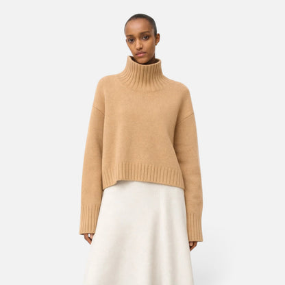 Shop Rescue Spa Girlfriend turtleneck sweater in beige chunky cashmere with sleeve slits worn by a model