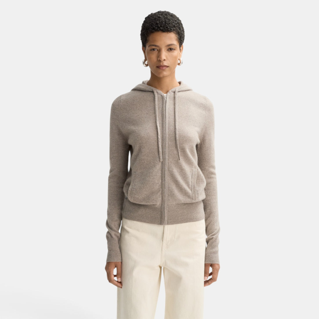 Shop Rescue Spa fine knit beige cashmere zip hoodie worn by a model with short hair against a white background