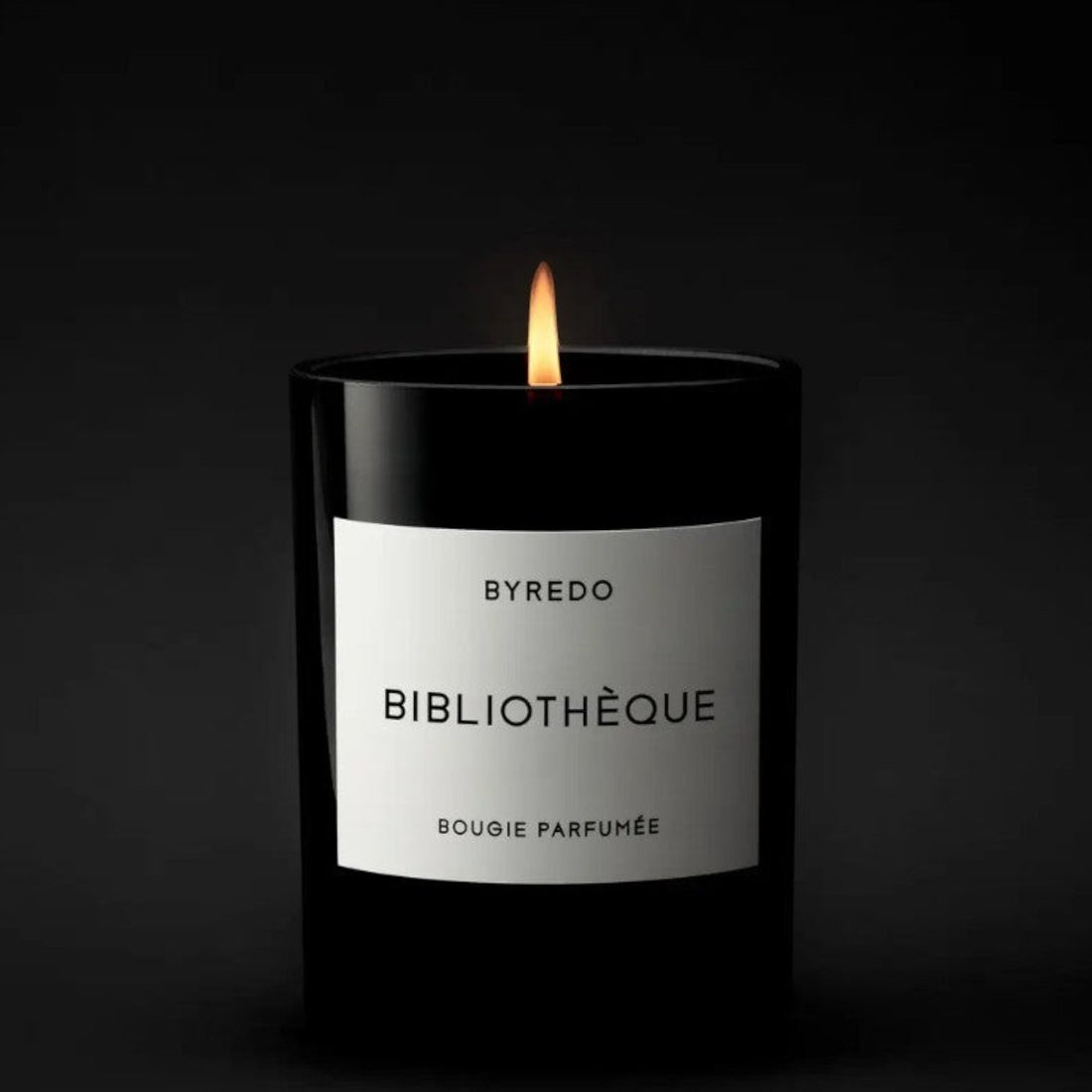 Shop Rescue Spa Bibliotheque candle in a black glass jar with a white label, featuring notes of peach, plum, peony, violet, leather, patchouli, and vanilla.