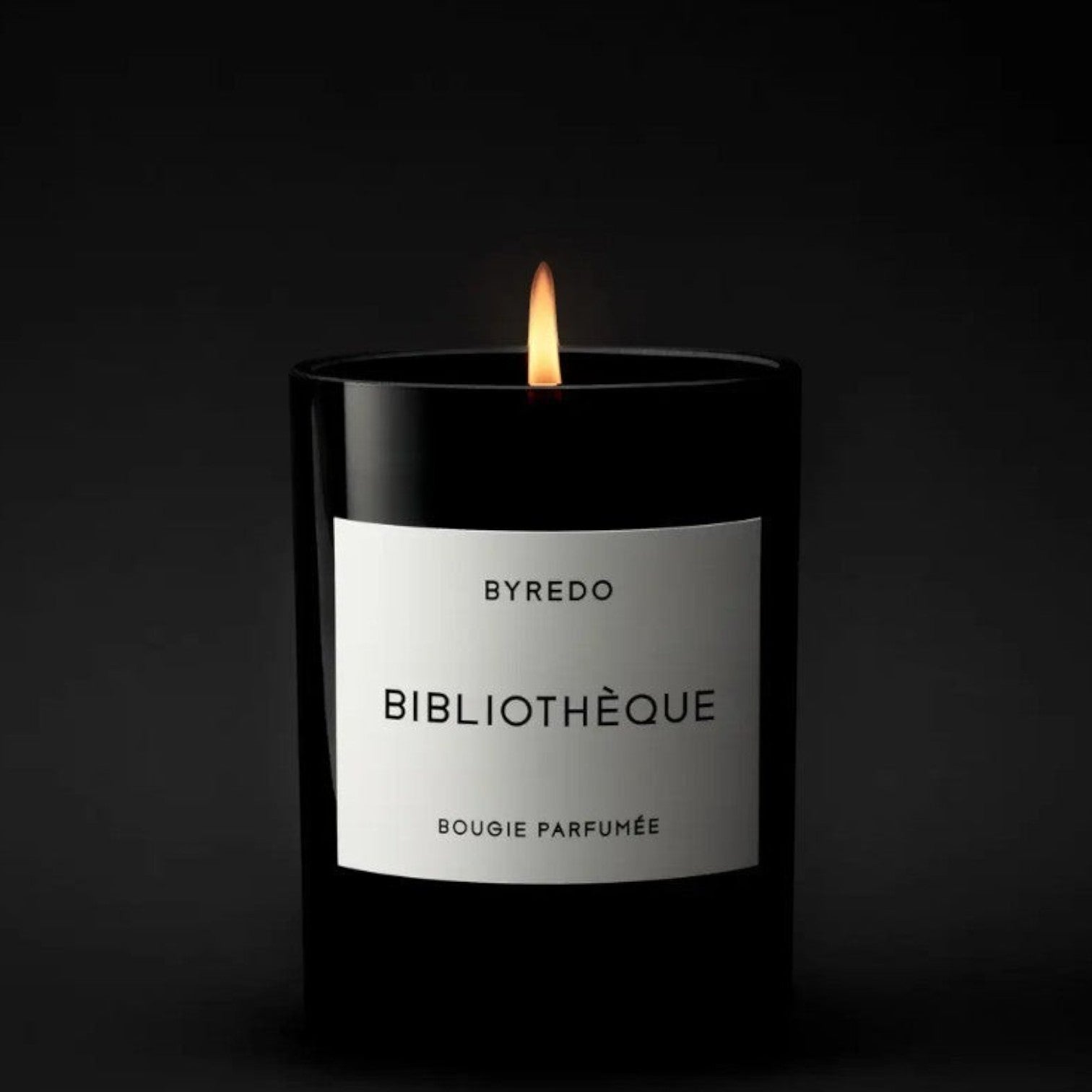 Shop Rescue Spa Bibliotheque candle in a black glass jar with a white label, featuring notes of peach, plum, peony, violet, leather, patchouli, and vanilla.