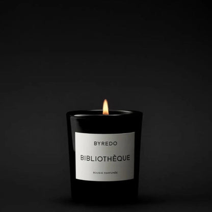 Shop Rescue Spa Bibliotheque scented candle in a black glass jar with a white label, lit flame.