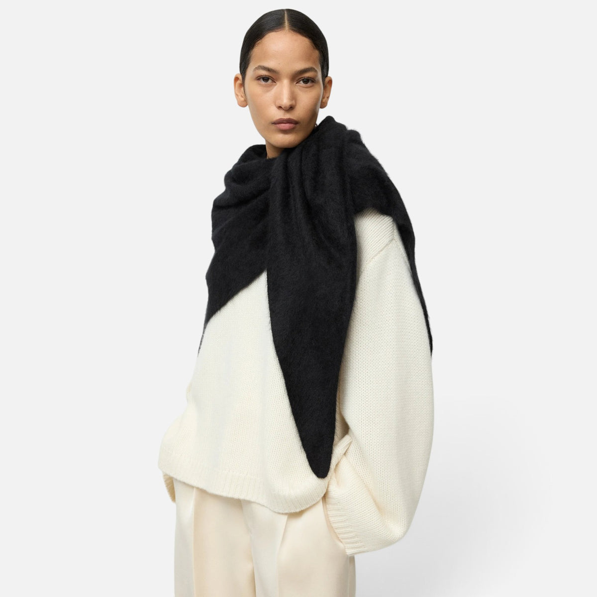 Shop Rescue Spa black brushed cashmere scarf draped over a model wearing a cream knit sweater