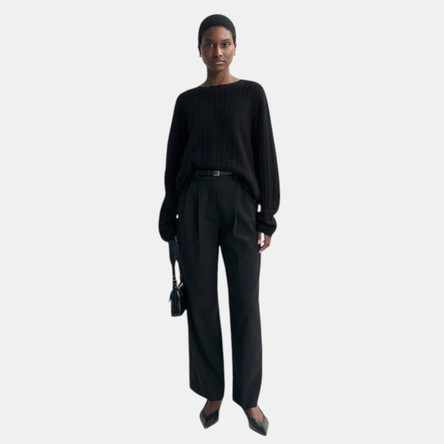 Shop Rescue Spa black oversized cable knit cashmere sweater worn by a model with black trousers and heels