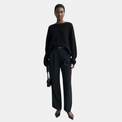Shop Rescue Spa black oversized cable knit cashmere sweater worn by a model with black trousers and heels