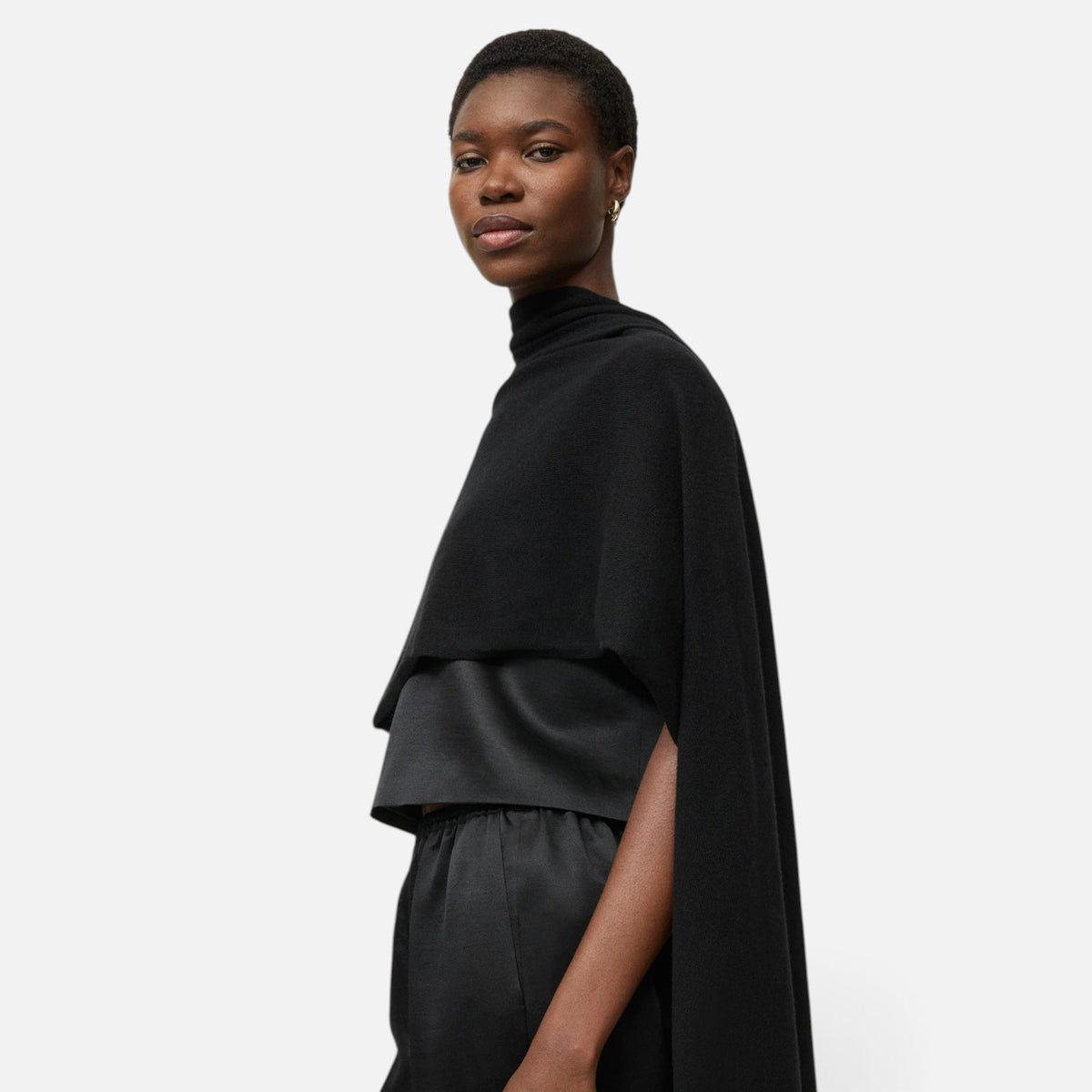 Shop Rescue Spa black fine knit cashmere scarf draped over the shoulders of a model against a white background.
