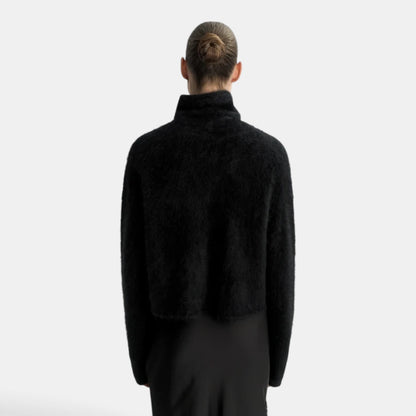 Back view of a model wearing a black Shop Rescue Spa brushed cashmere turtleneck sweater with a regular fit.