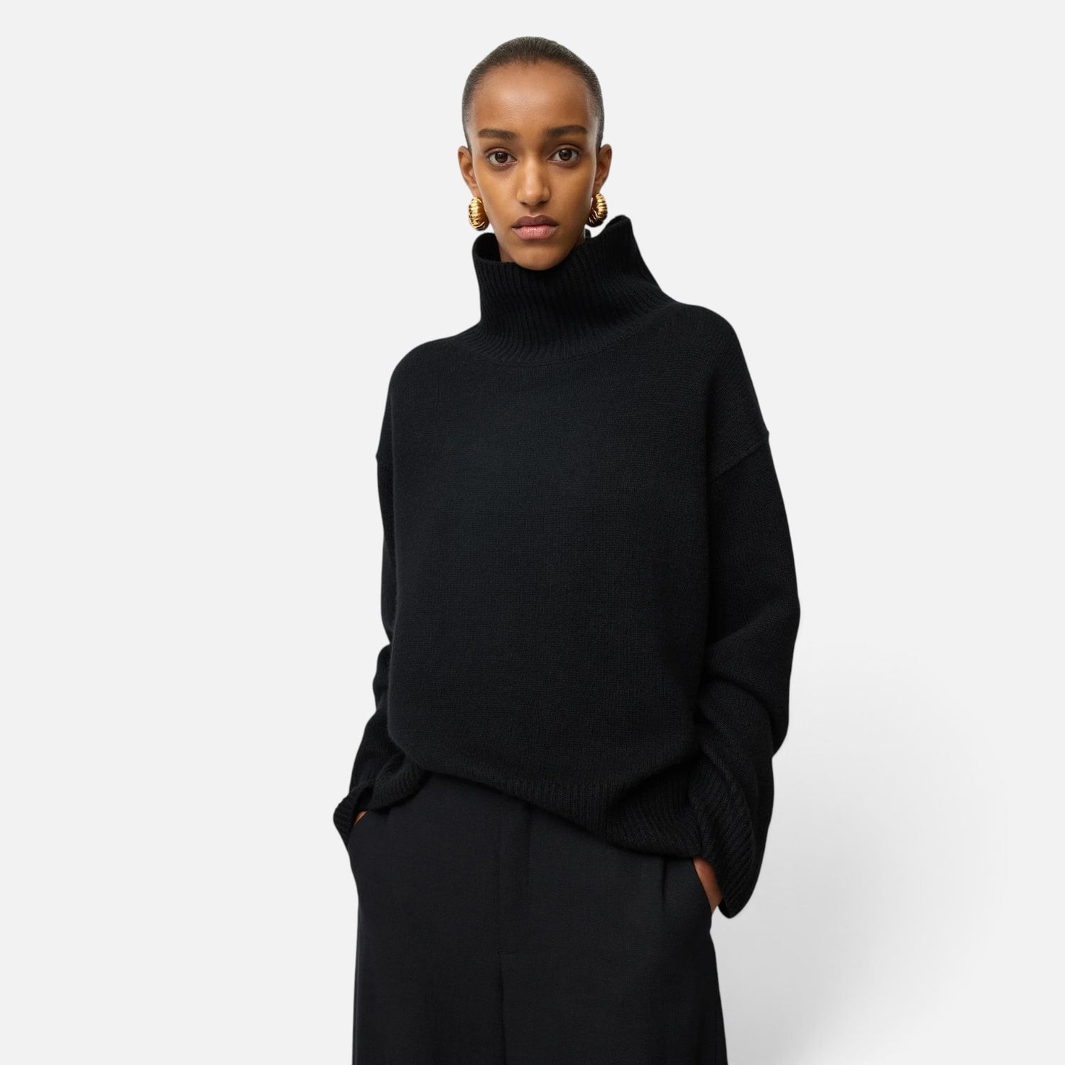 Model wearing a Shop Rescue Spa oversized black chunky knit cashmere turtleneck sweater with a relaxed fit.