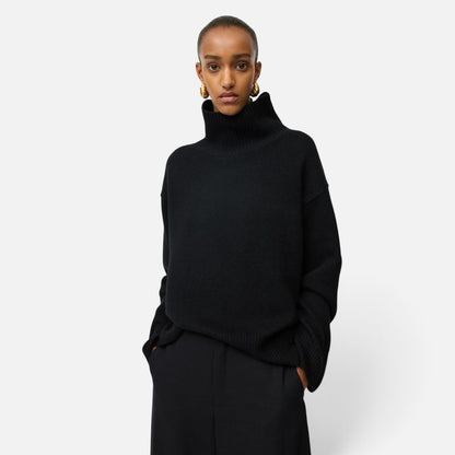 Model wearing a Shop Rescue Spa oversized black chunky knit cashmere turtleneck sweater with a relaxed fit.