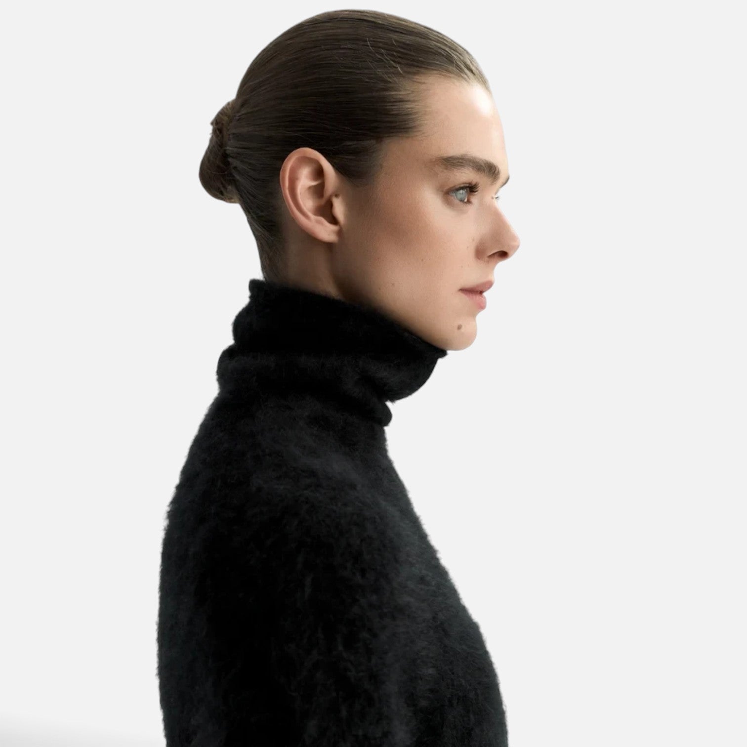 Shop Rescue Spa black chunky knit cashmere turtleneck sweater worn by a model in profile view