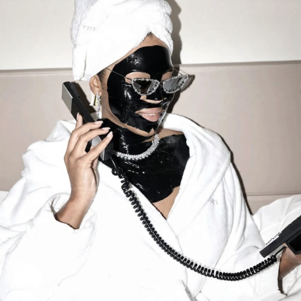 Shop Rescue Spa Black Diamond lifting and firming neck mask applied to a woman in a white robe and towel head wrap