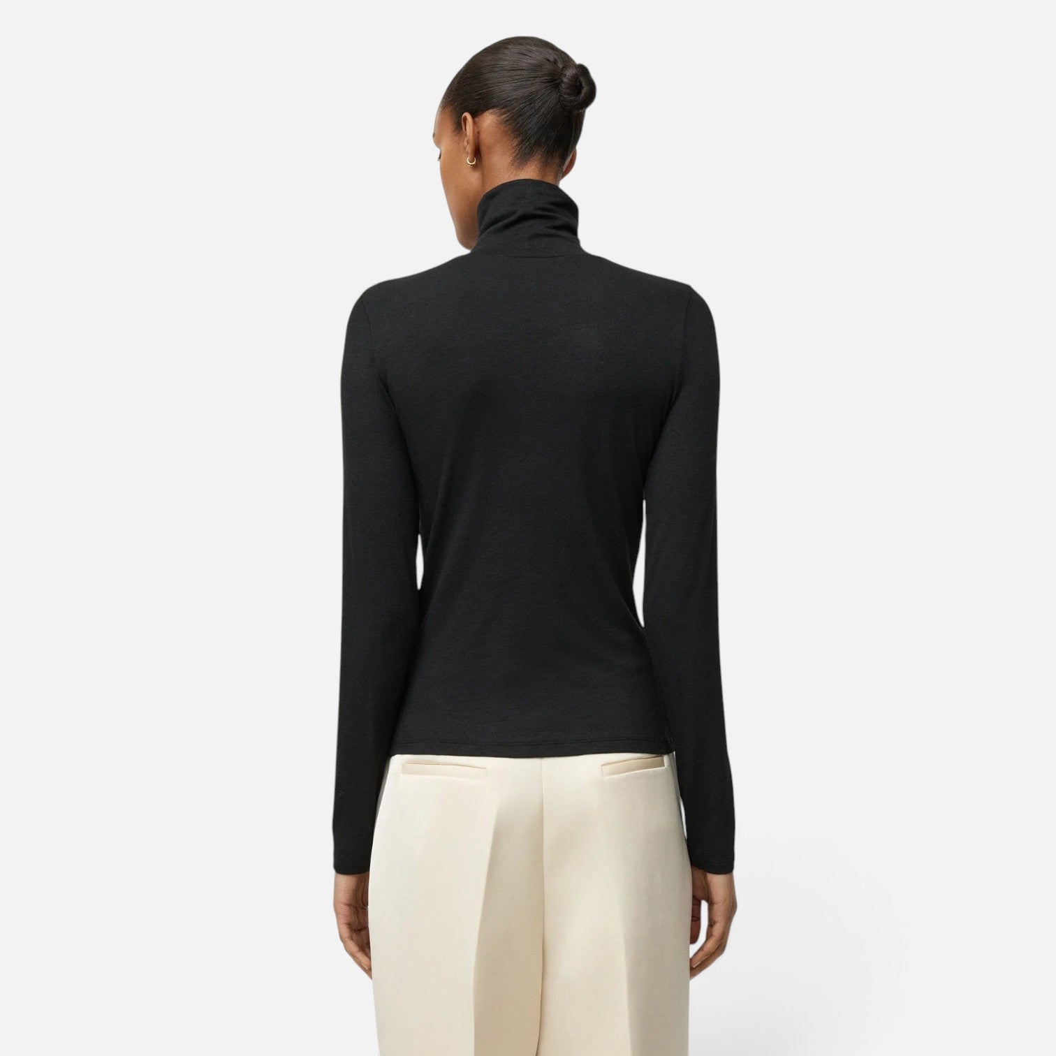 Shop Rescue Spa black lightweight jersey turtleneck worn by a model, back view showing long sleeves and slim fit.