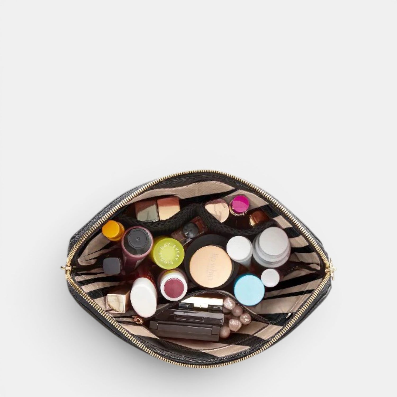 Shop Rescue Spa black leather makeup bag with organized compartments filled with various cosmetics and brushes.